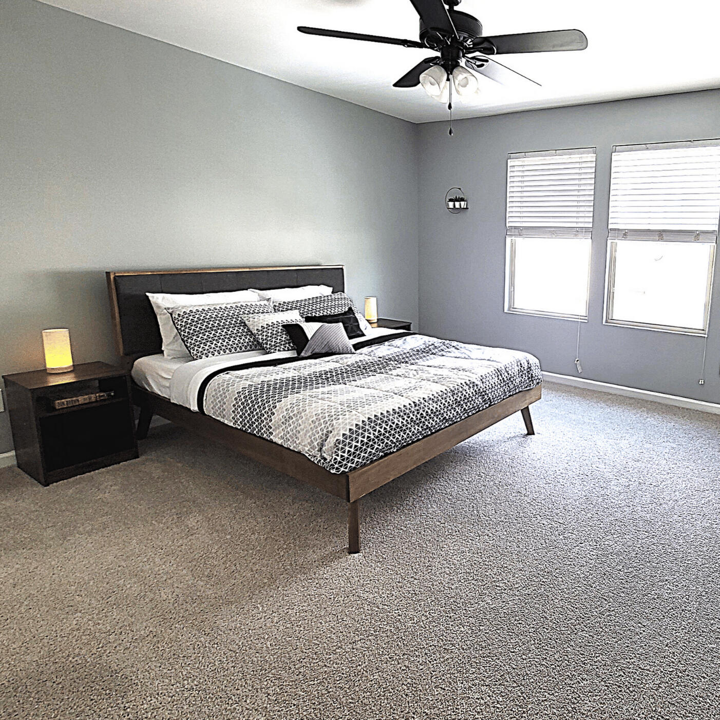 Primary bedroom with queen bed and ceiling fan in the Wake Forest rental home