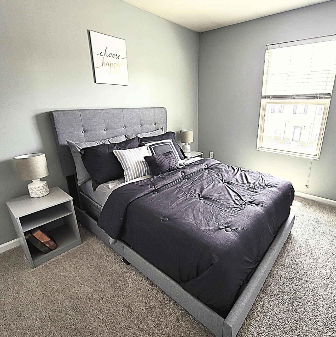 Bedroom with upholstered headboard and full bed in the Wake Forest rental home